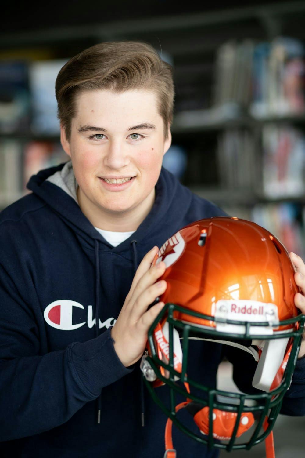 Photo d'un adolescent tenant un casque de football